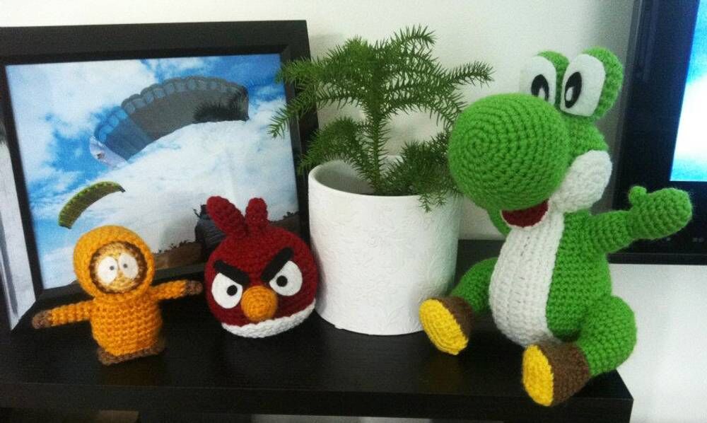 Crocheted Yoshi beside a framed skydiving print